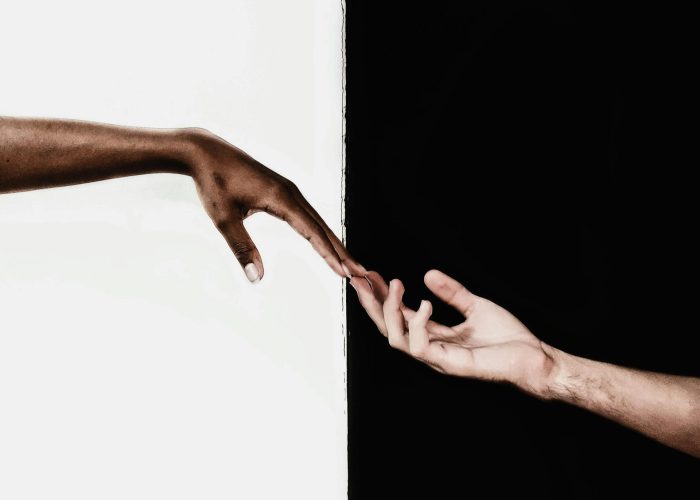 Symbolic image of two hands reaching toward each other, representing unity and diversity.